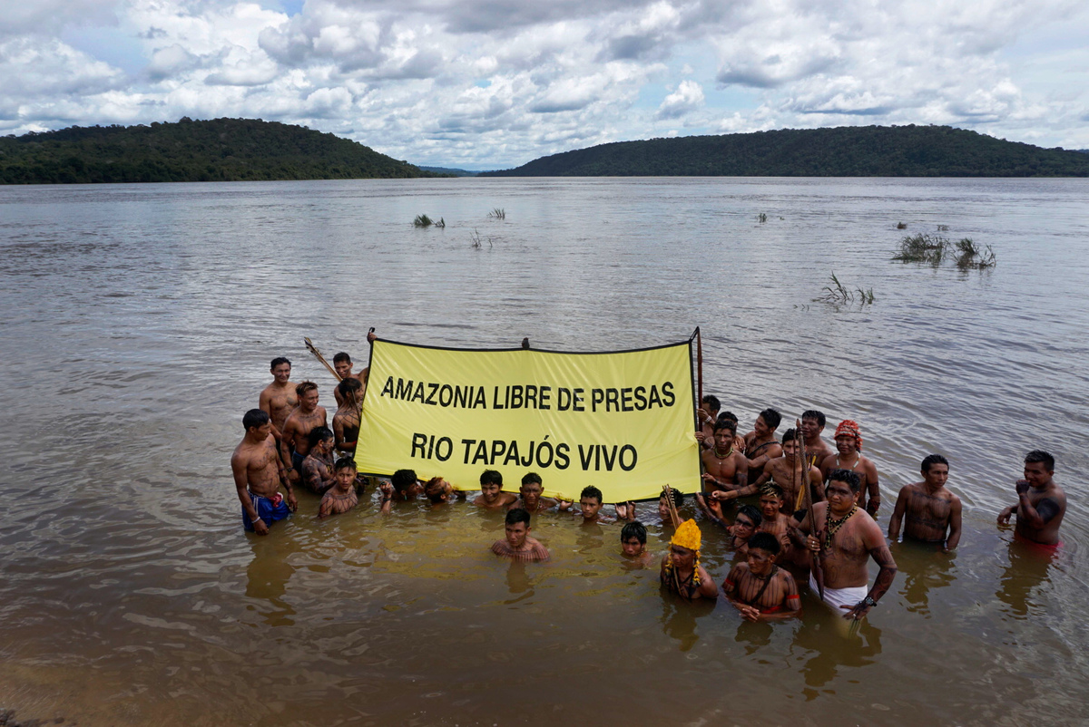 Para marcar o Dia Internacional das Florestas (21 de março), lideranças Munduruku foram até um trecho do rio Tapajós considerado sagrado pelo povo para passar um recado para o mundo: “Mantenham o Rio Tapajós vivo”. Segurando faixas em diversas línguas, eles protestaram, ao lado de ativistas do Greenpeace, contra a construção de barragens no rio que sustenta sua cultura e modo de vida. Ao todo, há 43 grandes hidrelétricas previstas para a bacia do Tapajós, sendo cinco já planejadas. A maior delas é a de São Luiz do Tapajós, próxima a Itaituba, no Pará, que, se construída, vai afetar a vida de povos indígenas e ribeirinhos, além de destruir uma área de intensa biodiversidade na Amazônia. Terra Indígena Sawré Muybu - Itaituba, Pará. 18/03/2016. Foto: Rogério Assis/Greenpeace.Greenpeace Brazil activists have joined forces with Munduruku Indigenous leaders to protest the Brazilian government's plans to build a mega dam on the Tapajós river, in the heart of the Brazilian Amazon rainforest in the Pará state.Using traditional canoes, activists have joined the Munduruku on a sacred part of the Tapajós River to send a clear message to the world: "Damn the dam. Keep the Tapajós river alive". Together, they unfurled a 20X30 meter banner on the river demanding an end to the São Luiz do Tapajós dam. The protest celebrates the International Day of Forest, on March 21st. Sawré Muybu Indigenous Land - Itaituba, Pará, Brazil. 18/03/2016. Photo: Rogério Assis/Greenpeace.