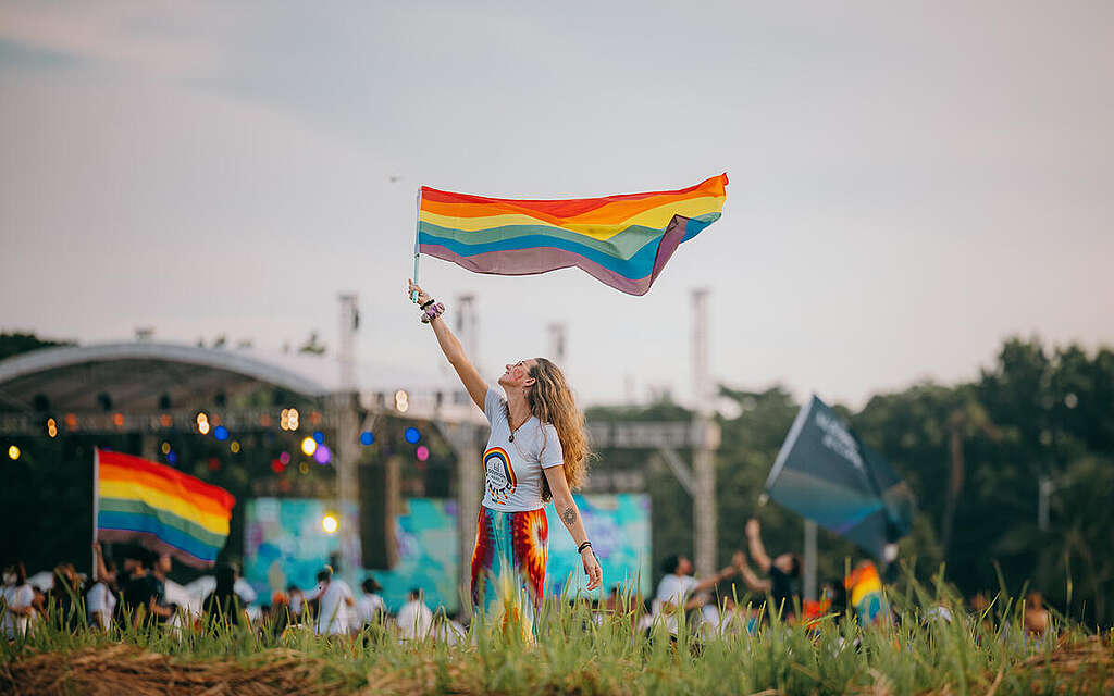 Ragazza in un prato sventola la bandiera del movimento LGBTQIA2S+ Ragazza in un prato sventola la bandiera del movimento LGBTQIA2S+