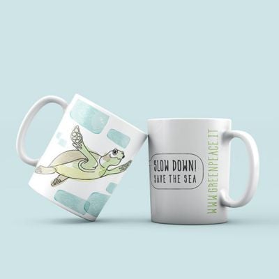 Tazza in ceramica bianca con tartaruga disegnata e scritta "Slow down, save the sea". Tazza in ceramica bianca con tartaruga disegnata e scritta "Slow down, save the sea".