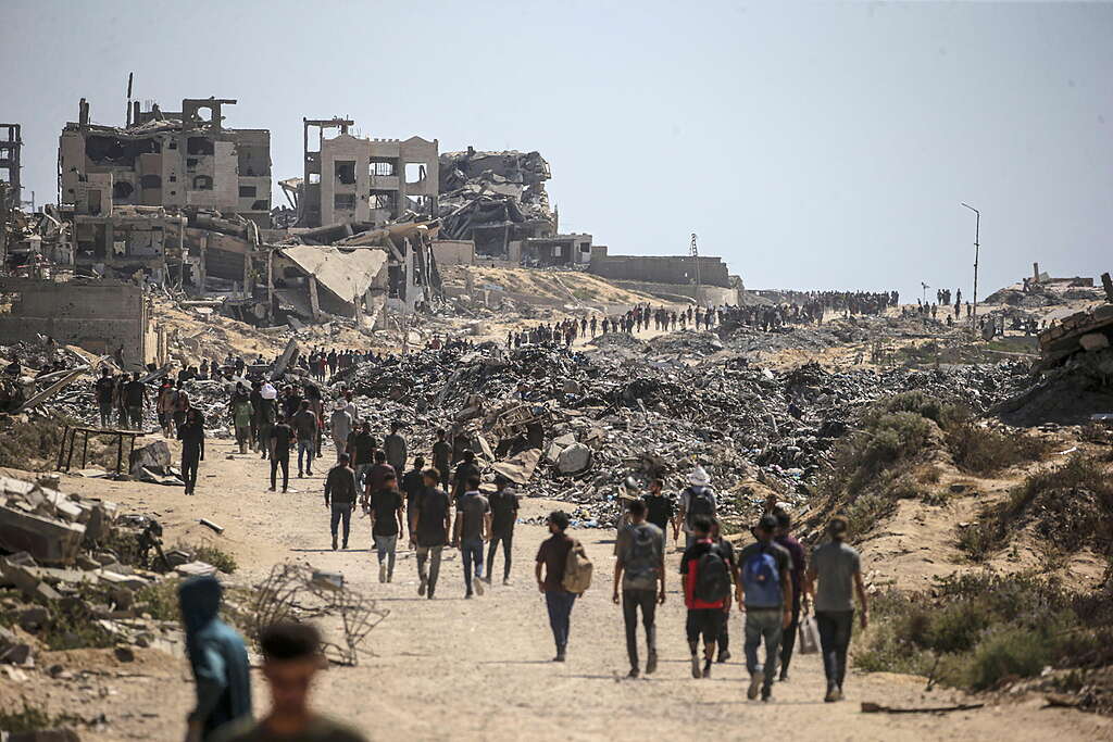 Profughi palestinesi camminano lungo Rashid Road nella zona occidentale di Jabalia, nella Striscia di Gaza, il 20 luglio 2025.