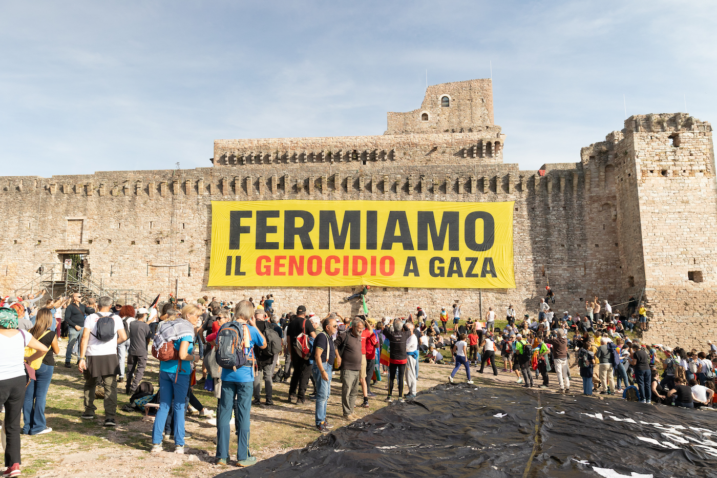 “Fermiamo il genocidio a Gaza”: L’enorme striscione di Greenpeace sulla rocca di Assisi per la marcia per la pace