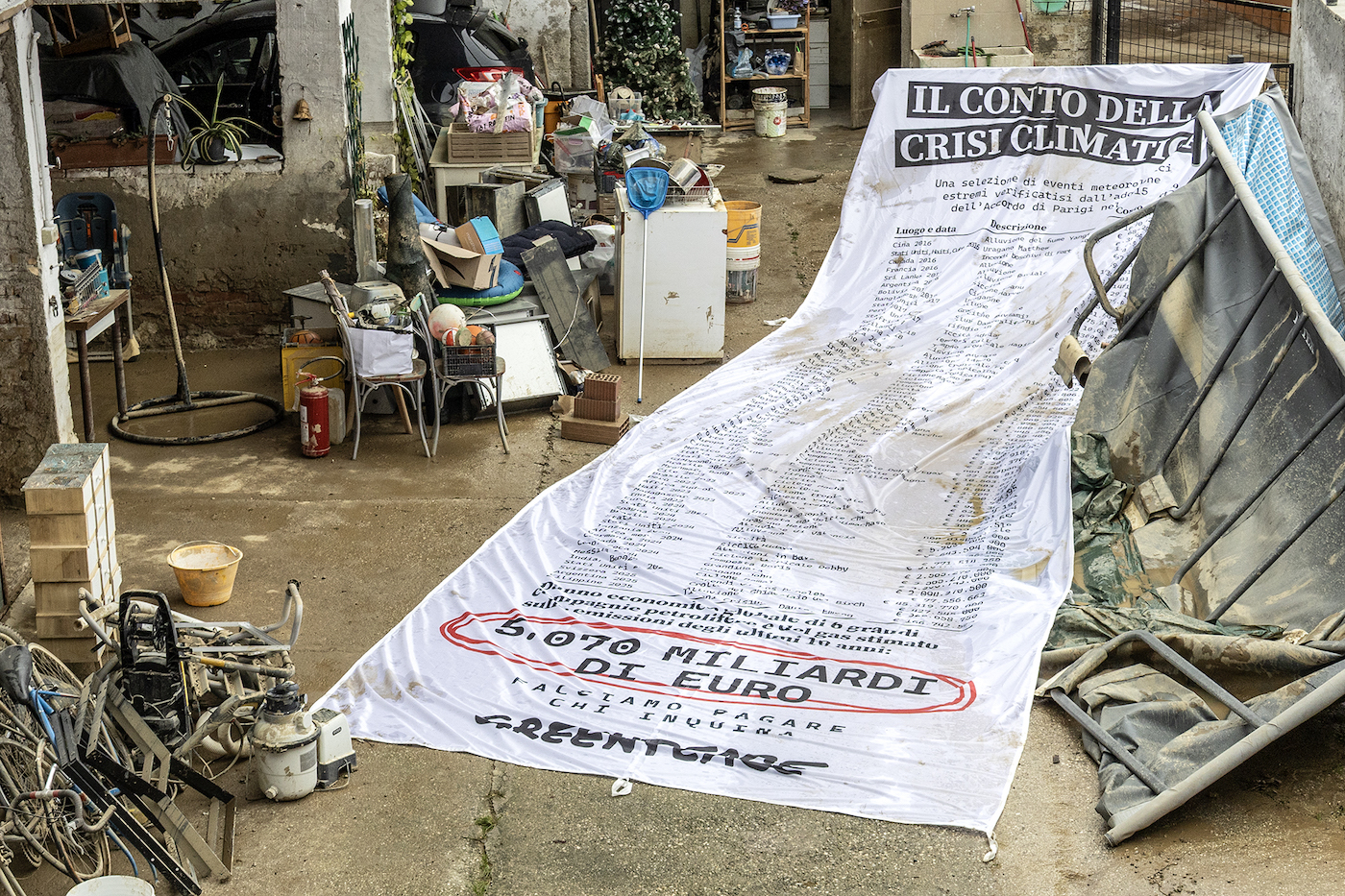 Cop30, lo scontrino gigante di Greenpeace nel fango del Friuli-Venezia Giulia: “Questo è il prezzo della crisi climatica”