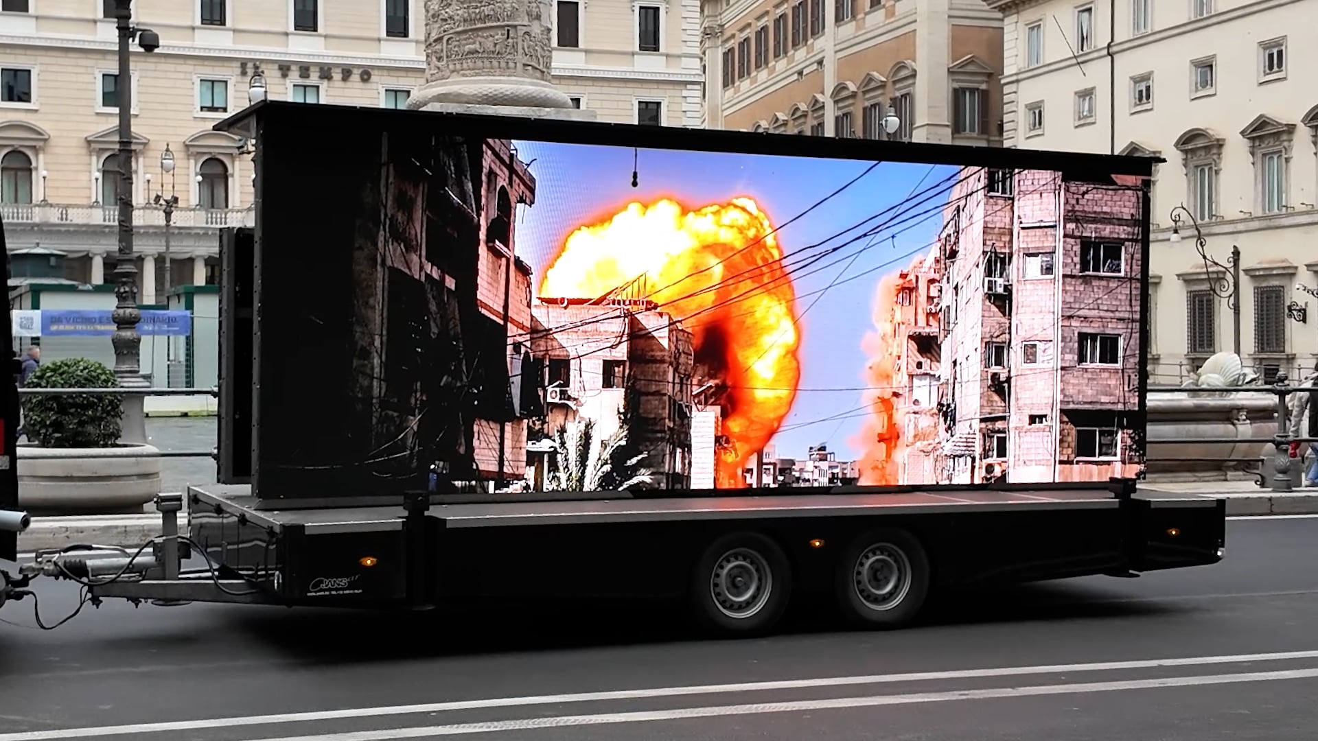 Uno schermo con le immagini dei bombardamenti a Gaza davanti a Palazzo Chigi per chiedere una vera tregua