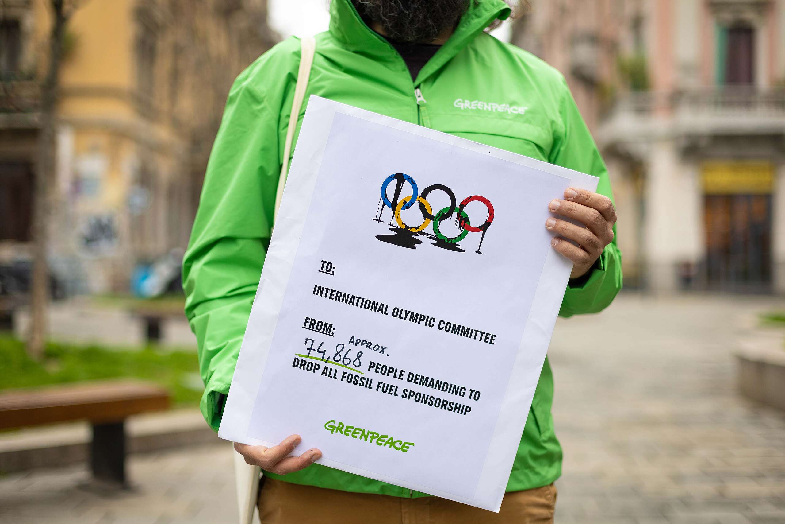 Olimpiadi Milano Cortina, Greenpeace consegna al Comitato Plimpico Internazionale decine di migliaia di firme per chiedere di rinunciare agli sponsor inquinanti