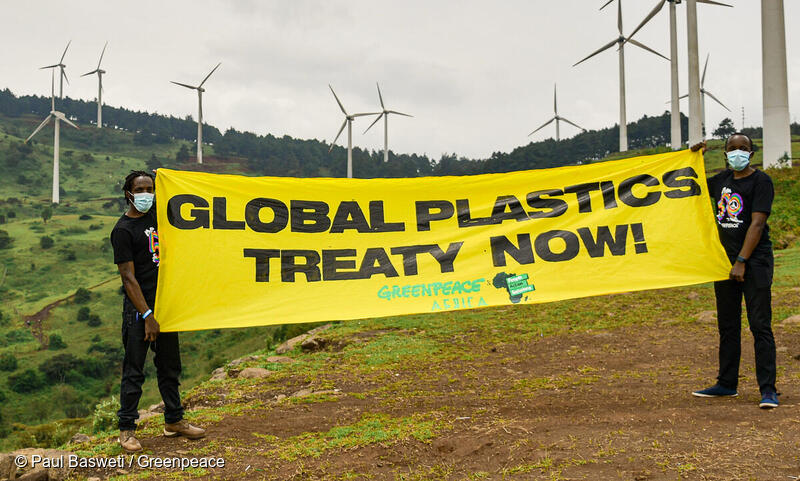 国際プラスチック条約を支持して、バナーを掲げる活動家。