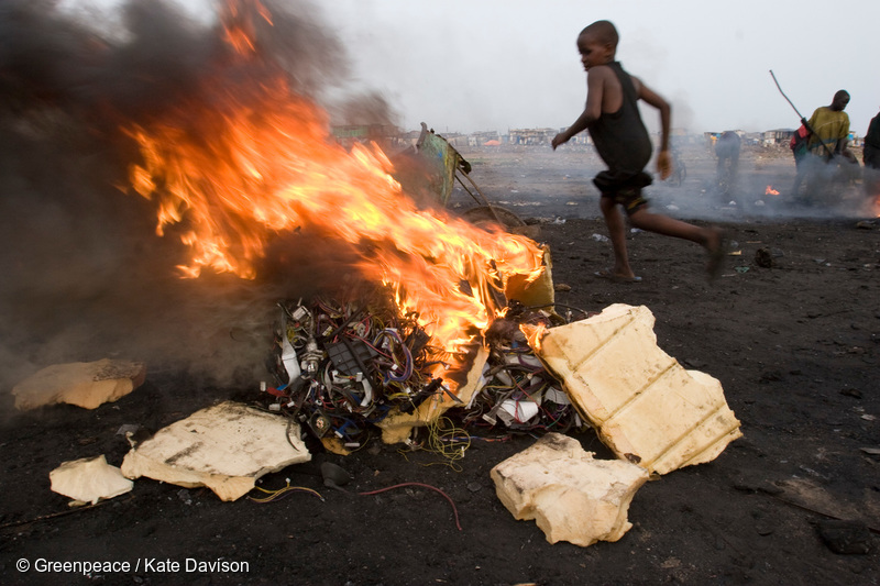 貧困に悩まされる国ではしばしば子どもが安全でない環境のリスクにさらされる。燃やされる電気製品のそばを走るガーナの子ども