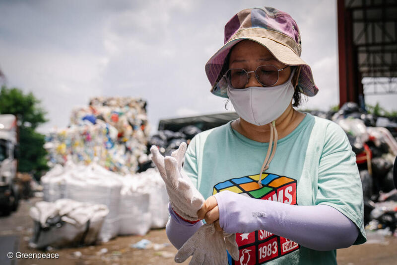 香港のプラスチックリサイクル工場で手袋をしてプラスチックの選別作業をするボランティア。 香港のプラスチックリサイクル工場で手袋をしてプラスチックの選別作業をするボランティア。