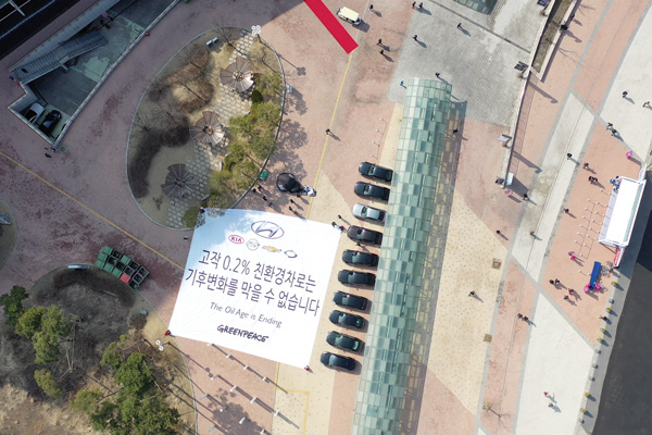 3월 29일 2019 서울 모터쇼 개막식 행사가 열린 경기 고양시 킨텍스 제 2전시관 앞에서 그린피스 활동가들이 '고작 0.2% 친환경차로는 기후변화를 막을 수 없습니다'라고 적힌 현수막을 펼치고 있다