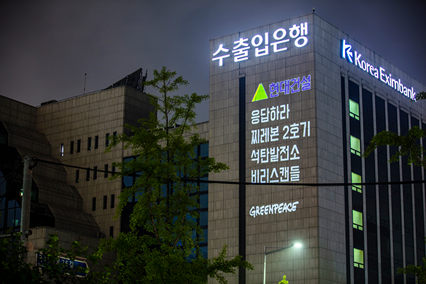 국제환경단체 그린피스 서울사무소가 6월 30일 저녁 여의도 수출입은행 건물에 레이저빔을 투사해 '해외 석탄 투자 멈춰라' 등의 메시지를 새겼다. (출처: 그린피스)