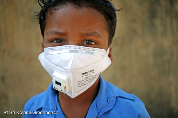 인도 차티스가르주의 한 남자아이가 근처 석탄발전소에서 날아오는 석탄재를 피하기 위해 마스크를 쓰고 있다. 