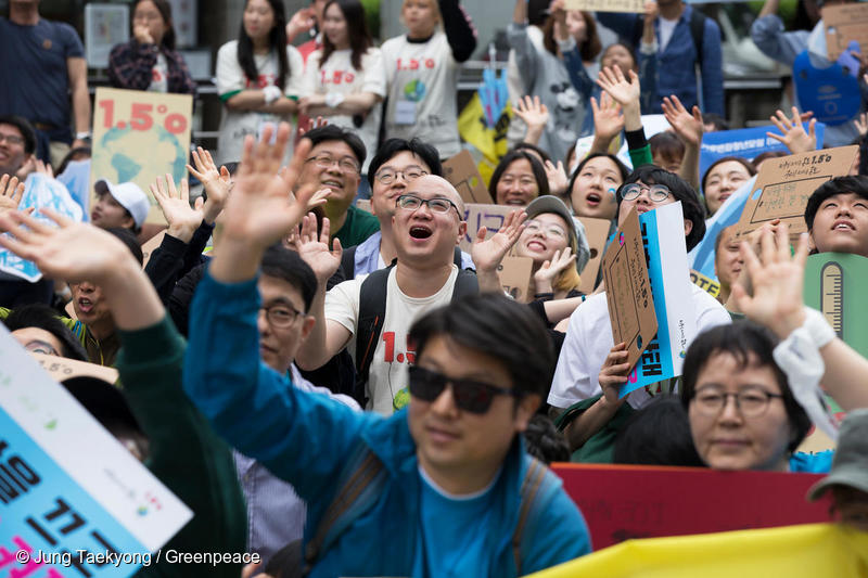 기후행진 2018에 참여한 시민이 카메라를 향해 손을 흔들어 보이는 모습