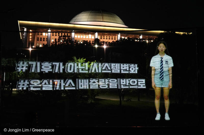 그린피스 서울사무소는 6월15일 오후 8시30분 서울 여의도 한강공원에서 국회를 배경으로 청년과 청소년 대표 33인이 출연해 정치권에게 기후위기 즉각 대응을 촉구하는 홀로그램 퍼포먼스를 벌였다. 행사에 참여한 시민대표가 2030년까지 온실가스 배출을 절반으로 줄일 것을 요구하고 있다.