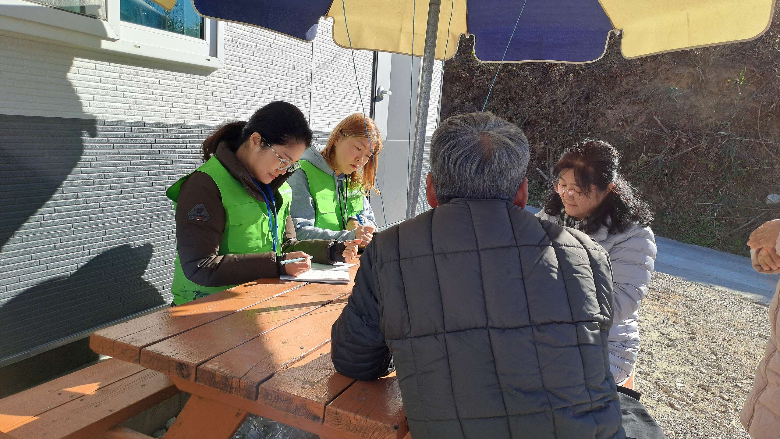 24년 12월, 심리전문가의 설문조사 중 기후재난 시민대응단은 이재민의 증언을 노트에 기록하고 있다. 사진: 강성원 그린피스 기후재난 전문가