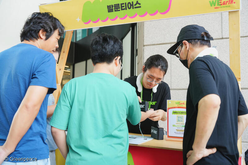 자원봉사자가 시민에게 캠페인을 안내하는 모습