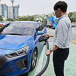 전기차를 충전하고 있는 시민 - 전기차 충전 인프라 확충도 전동화의 필수적인 요소이다