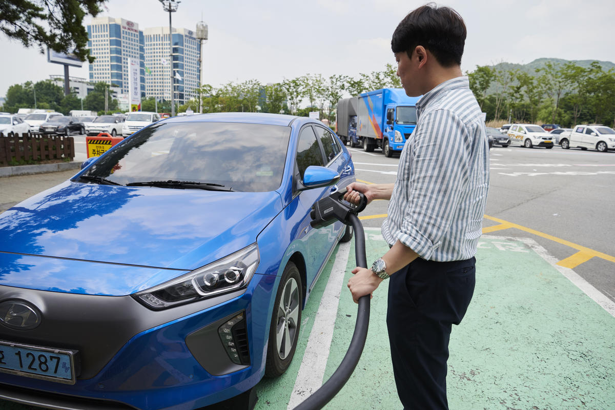 전기차를 충전하고 있는 시민 - 전기차 충전 인프라 확충도 전동화의 필수적인 요소이다
