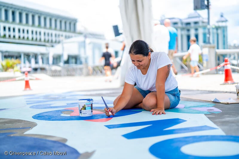 한 여성이 BBNJ 발효를 기념하는 벽화를 그리고있다.