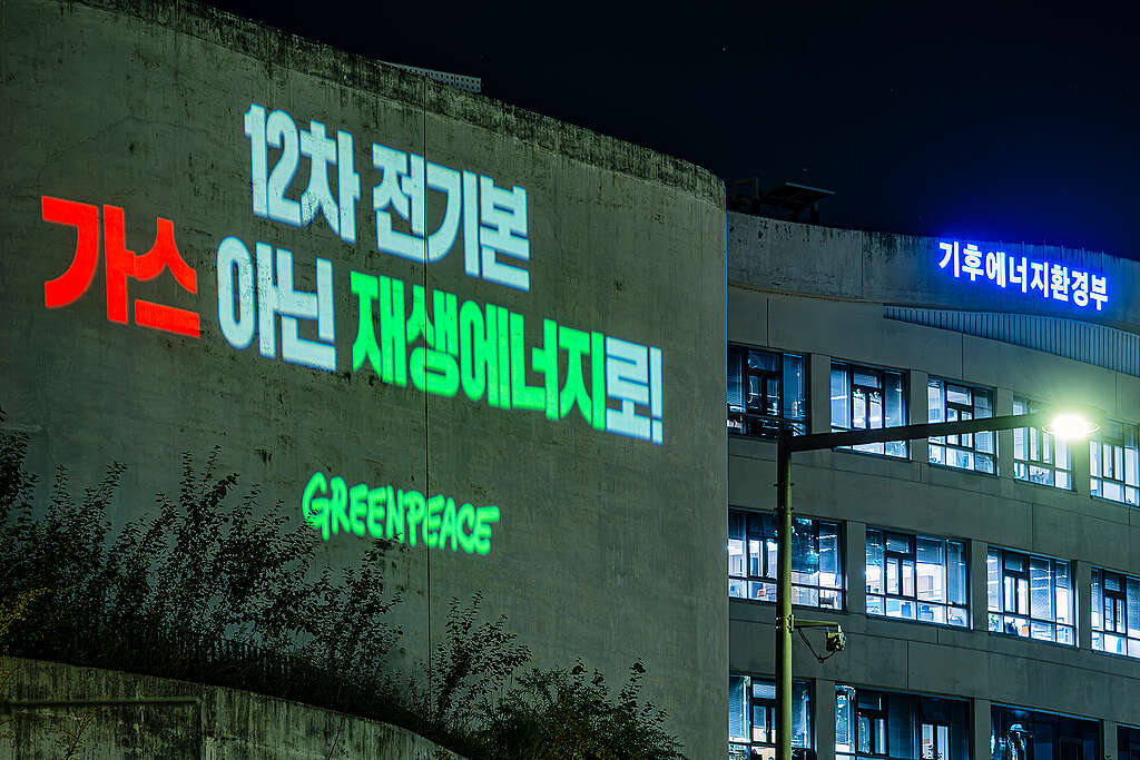 그린피스가 정부세종청사 기후에너지환경부 외벽에 제12차 전력수급기본계획에서 가스 발전 축소와 재생에너지 확대를 촉구하는 메시지를 투사하고 있다.