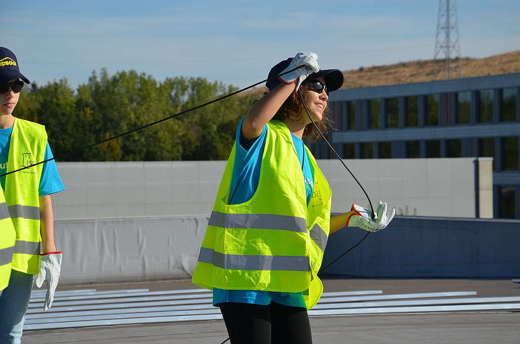 Jugendliche installieren Solarpaneele auf dem Dach der Sporthalle Henri Schmitz in Esch-Lallingen.