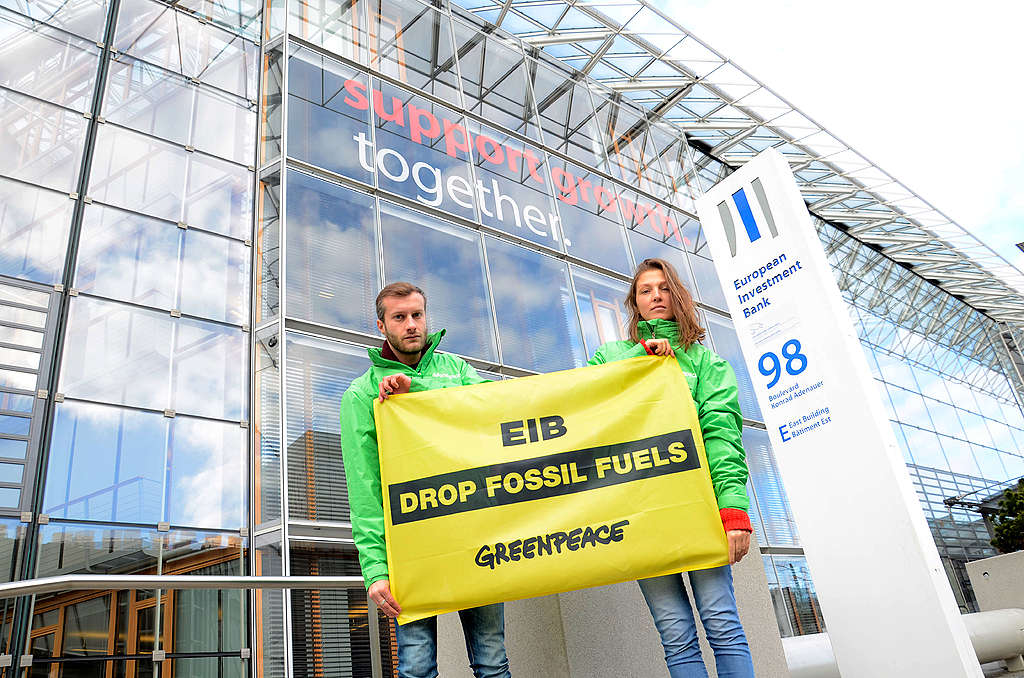 Des activistes devant le bâtiment de la BEI à Luxembourg. Ils tiennent une banderole demandant à la BEI de ne plus investir dans les combustibles fossiles.