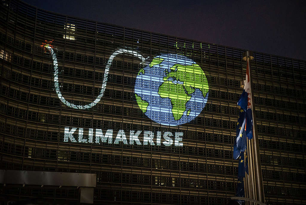 Klimaaktivisten von Greenpeace projizierten eine riesige Animation der Erde als Bombe mit brennender Zündschnur auf das Gebäude der EU-Kommission in Brüssel.
