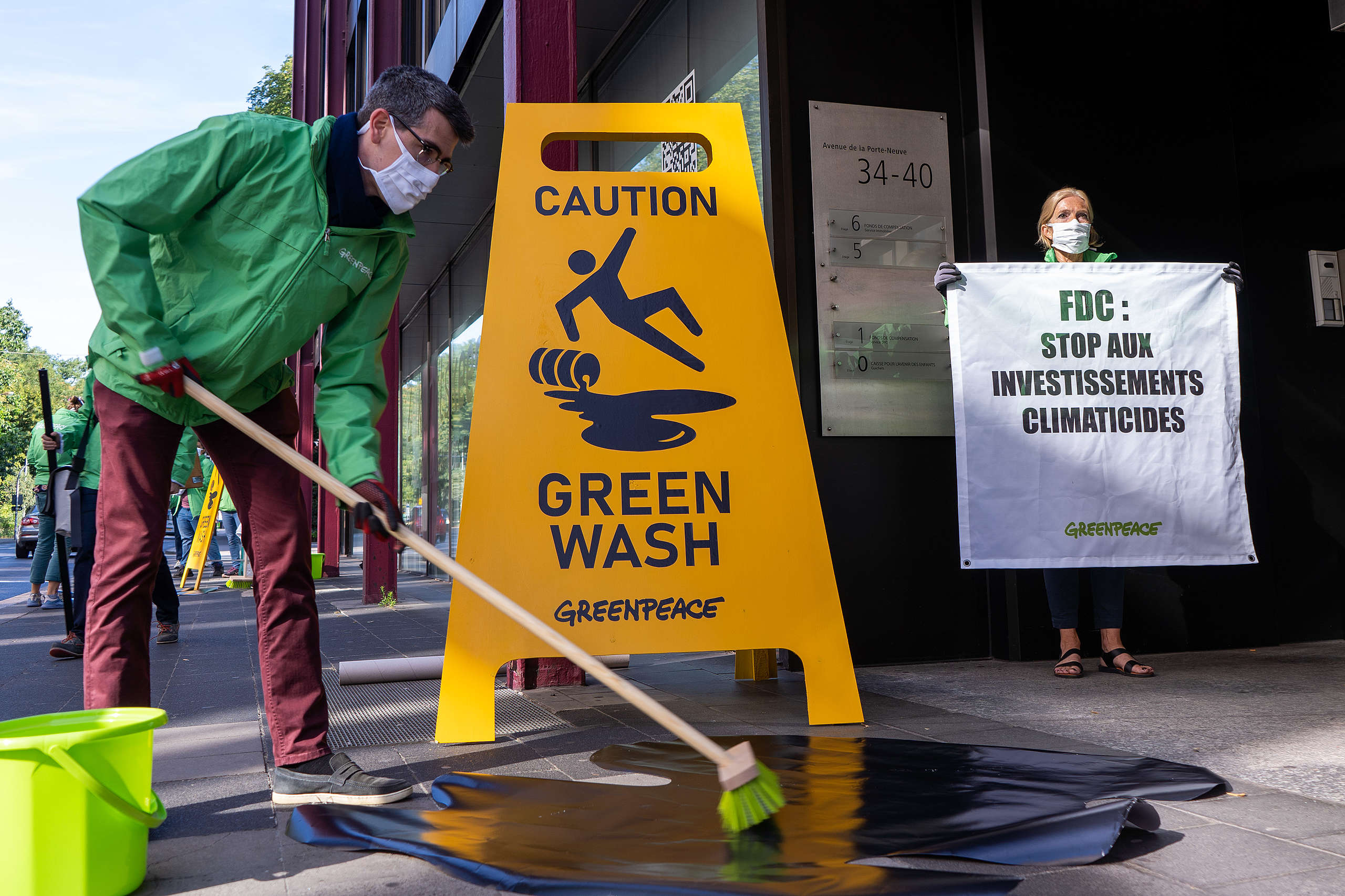 Menschengroße Schilder von Greenpeace am Sitz des luxemburgischen Pensionsfonds warnen vor Greenwashing