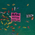 A flotilla of crafts, from fishing boats and yachts to kayaks and stand up paddle boards, surrounding a floating ‘ban bottom trawling’ banner at Mission Bay in Auckland, New Zealand in a show of opposition to bottom trawling in the Hauraki Gulf marine park. Hundreds of people turned out on the beach and on the water for the event organised by Greenpeace Aotearoa and Forest & Bird. Over 60 vessels joined the flotilla.