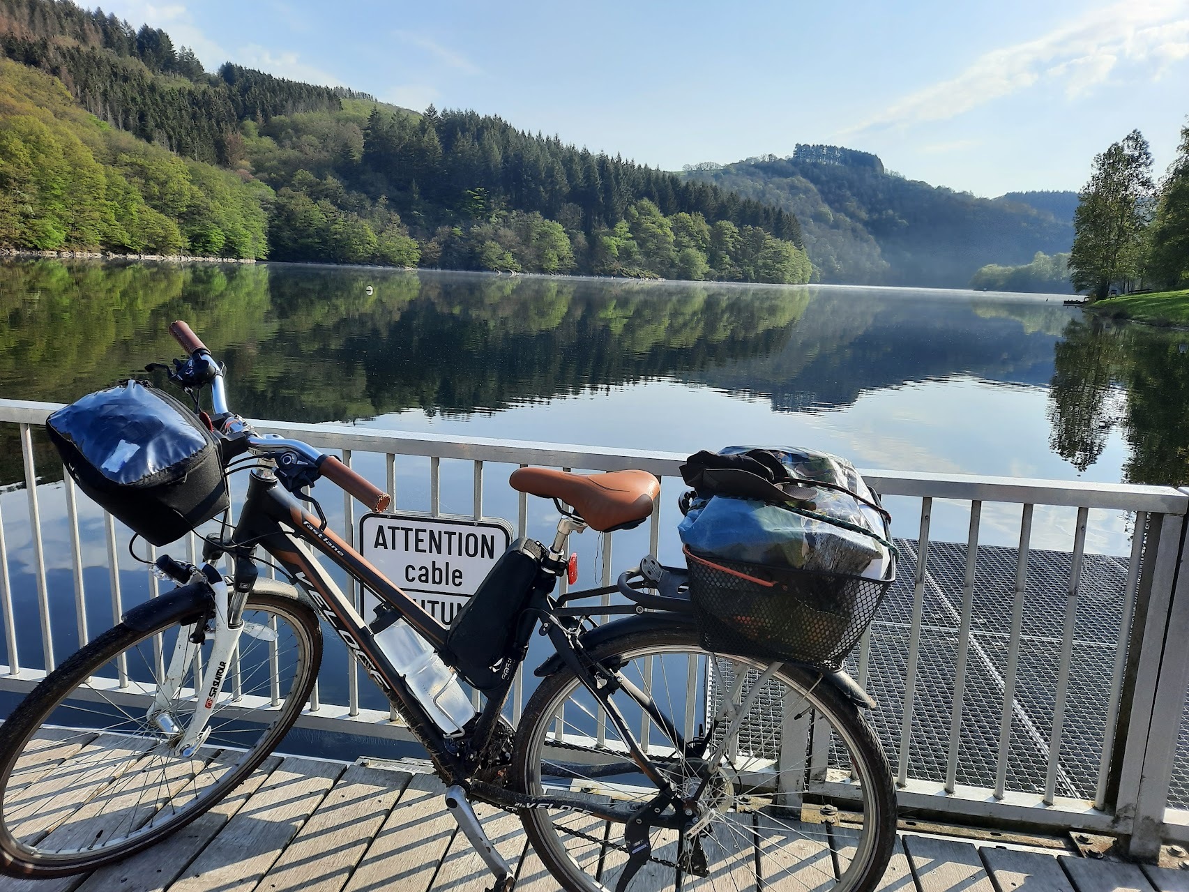 Photographie d'un vélo au bord d'un lac au Luxembourg. Le ciel est clair et le temps ensoleillé.