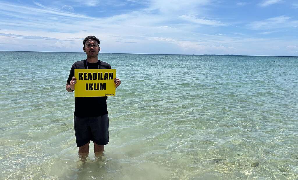 Aidil in front of Kampung Tajau Laut.