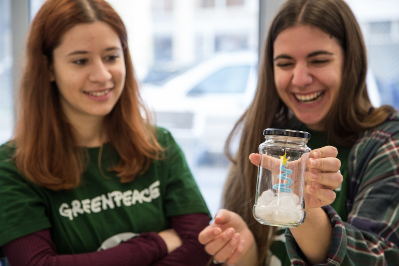 Dos voluntarias de Greenpeace en un taller de globos de nieve navideños con materiales reutilizados.