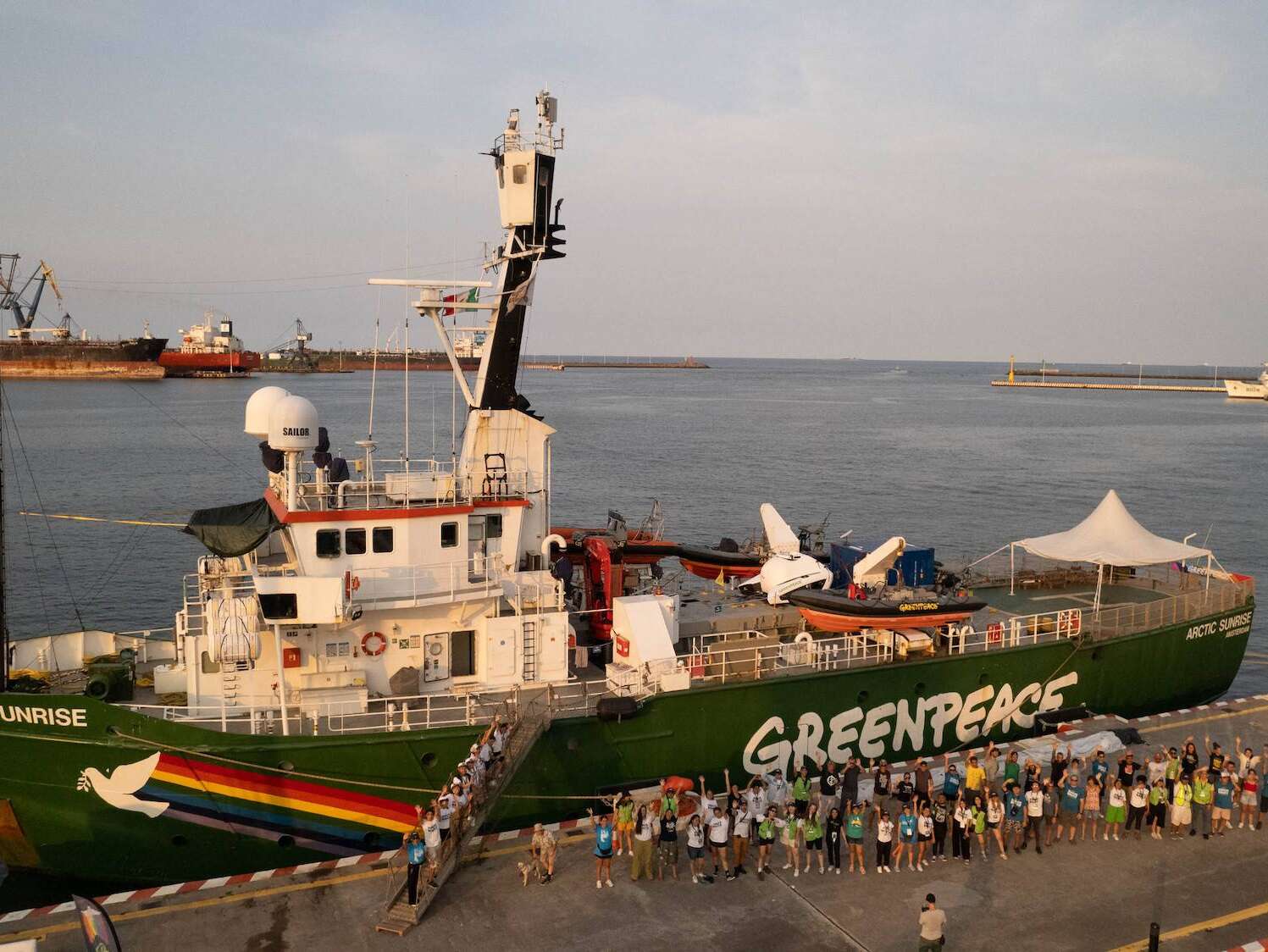 Toma aérea panorámica del Arctic Sunrise con voluntarios y comunidad en la zona.