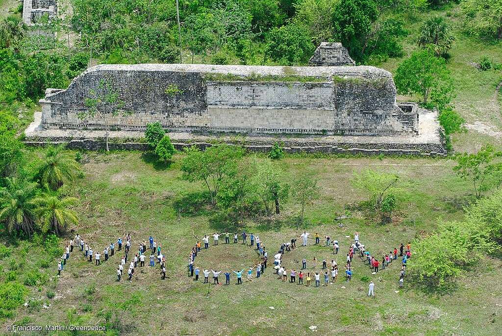 Vista aérea de personas formando la frase “MA OGM” junto a pirámides mayas en Yucatán, en protesta contra los transgénicos.