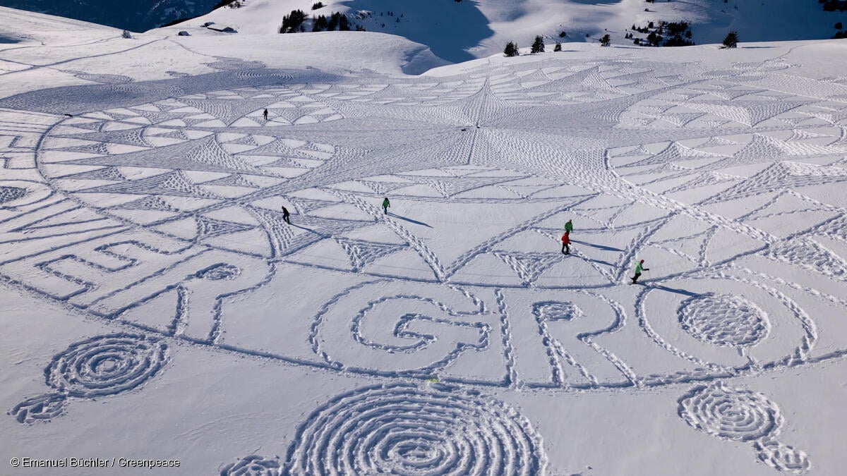 Activistas de Greenpeace y artista estampan espectacularmente el mensaje "¡La vida por encima del crecimiento!" en la nieve cerca de Davos.