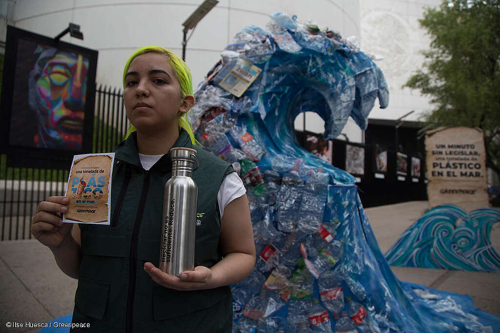 Una activista de Greenpeace muestra un envase de metal como alternativa a las botellas de plástico durante una acción frente al Senado mexicano para exigir una ley que prohíba el uso de plásticos de un solo uso.