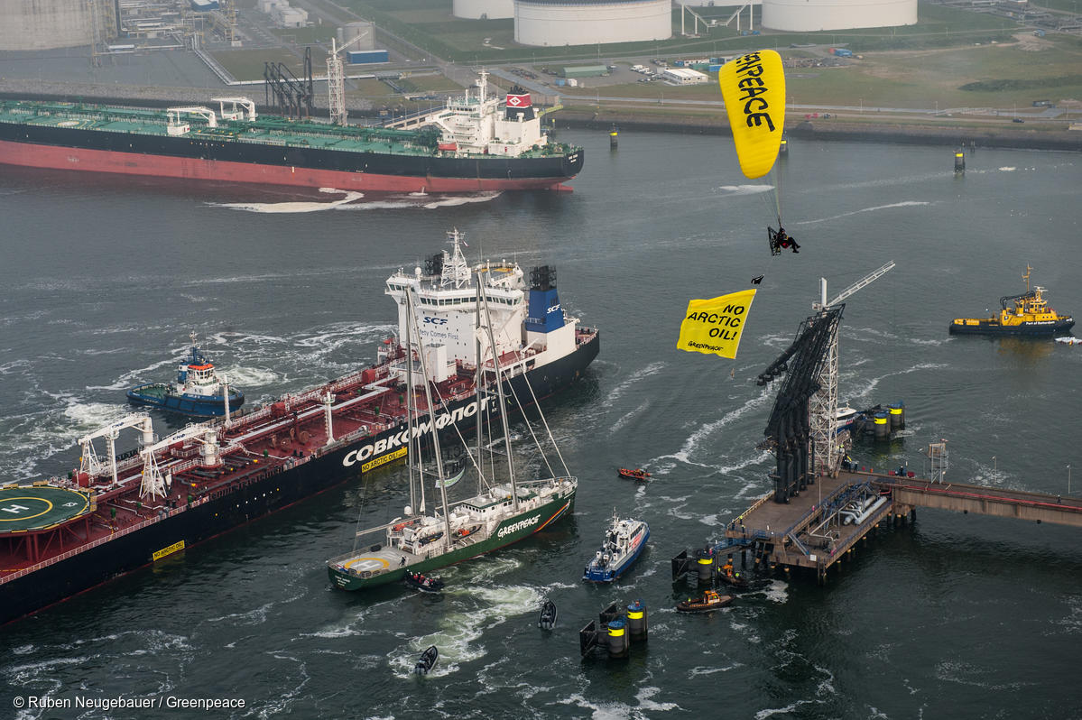Protesta contra el envío de petróleo del Ártico en Róterdam con un paracaidista que lleva una manta que dice "Sin petróleo en el ártico".