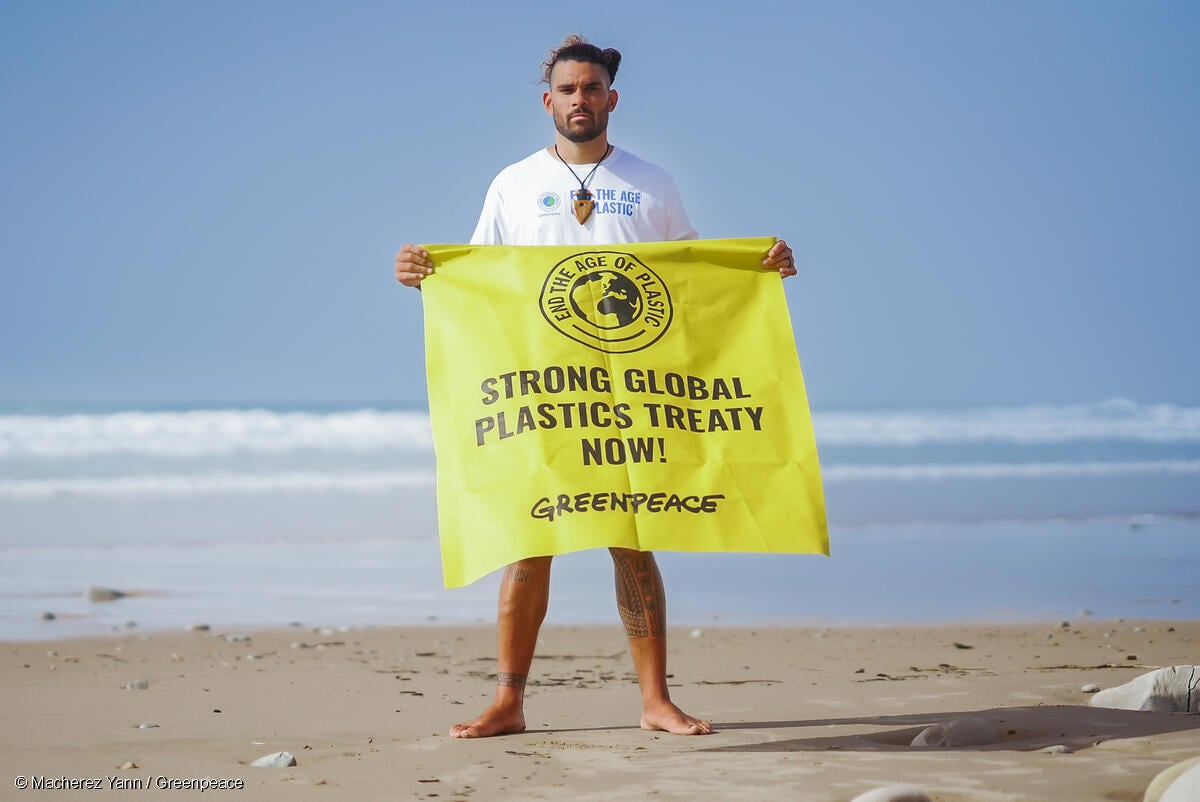 Un activista sostiene una manta con el mensaje “Un sólido tratado global de plásticos ya” durante las negociaciones INC-3, exigiendo un acuerdo ambicioso para frenar la contaminación por plásticos.