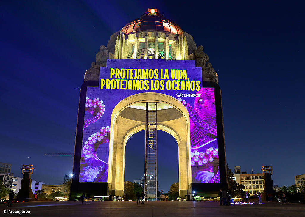 Fotografía del monumento a la revolución con una proyección que dice "Protejamos nuestros océanos"
