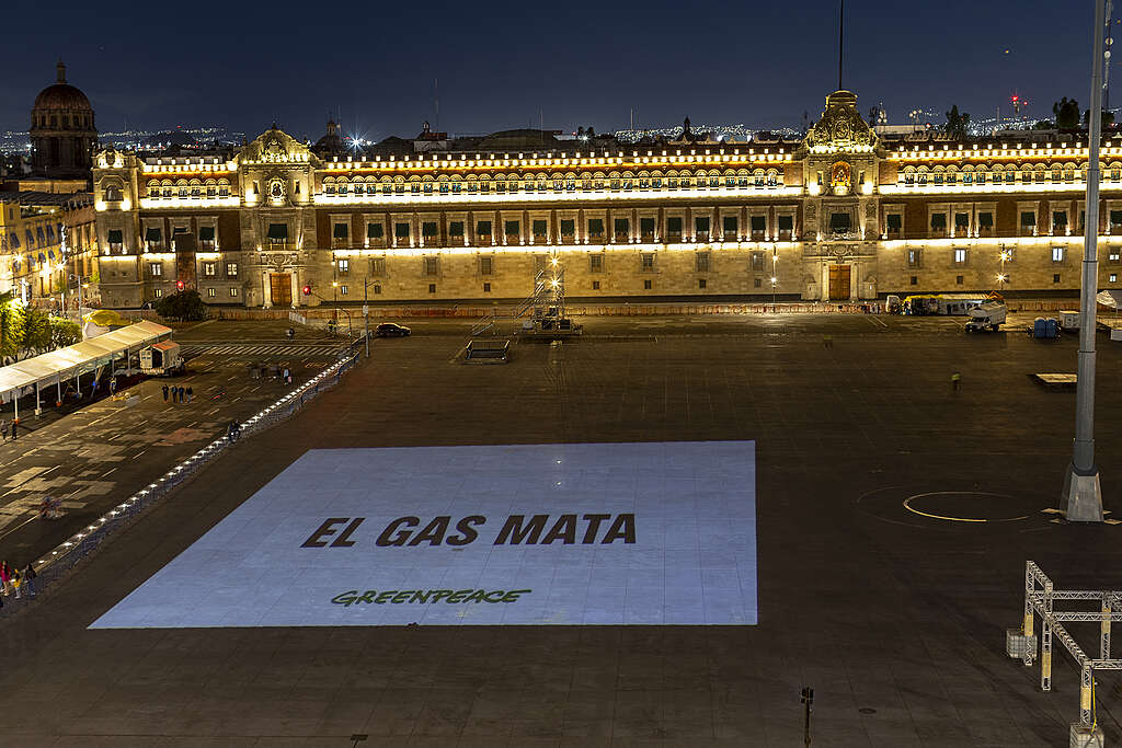 Proyección en el piso de la plaza frente al Palacio Nacional con la frase "El gas mata", como parte de una protesta ambiental.