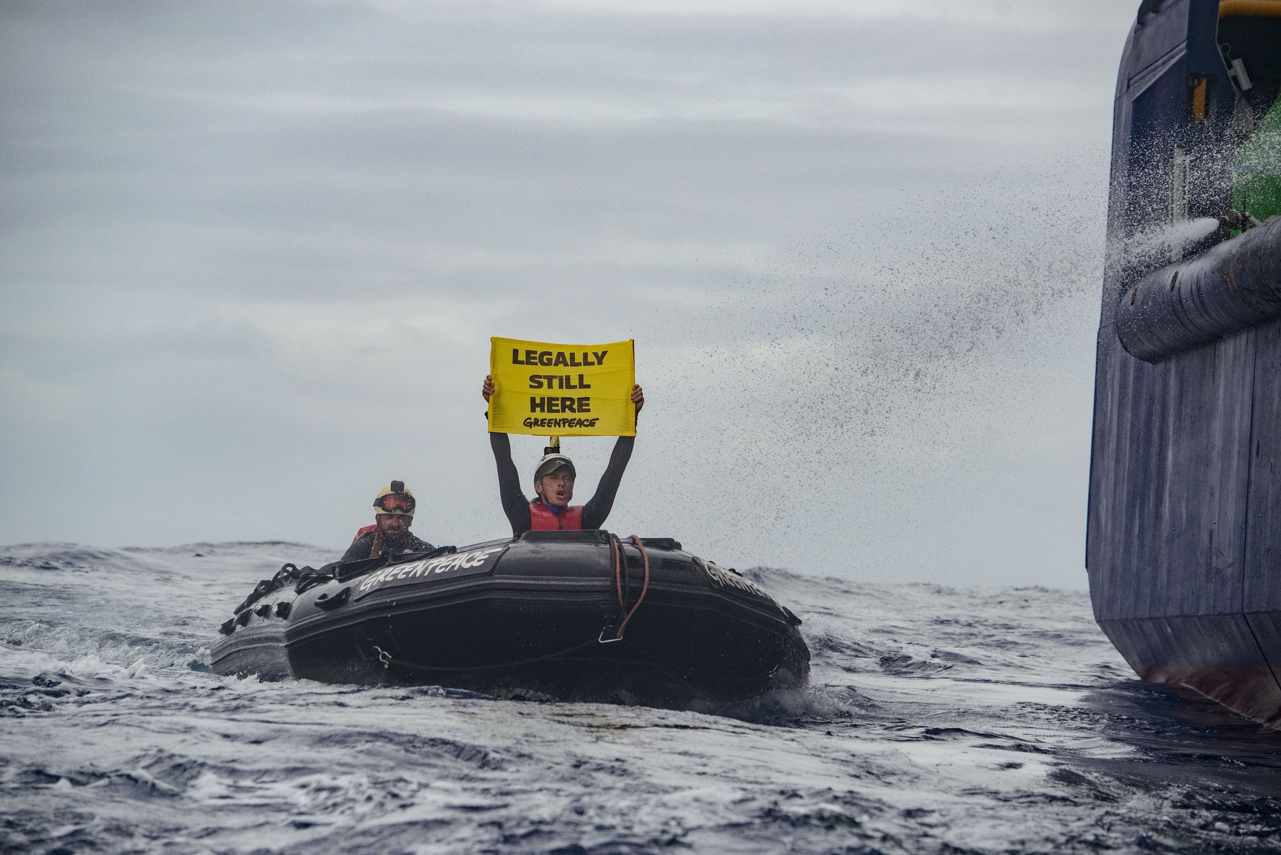 Activistas de Greenpeace de todo el mundo protestan en kayaks alrededor del buque perforador MV COCO, sosteniendo un cartel que dice “Legally still here”, destacando que su acción es legítima y pacífica.