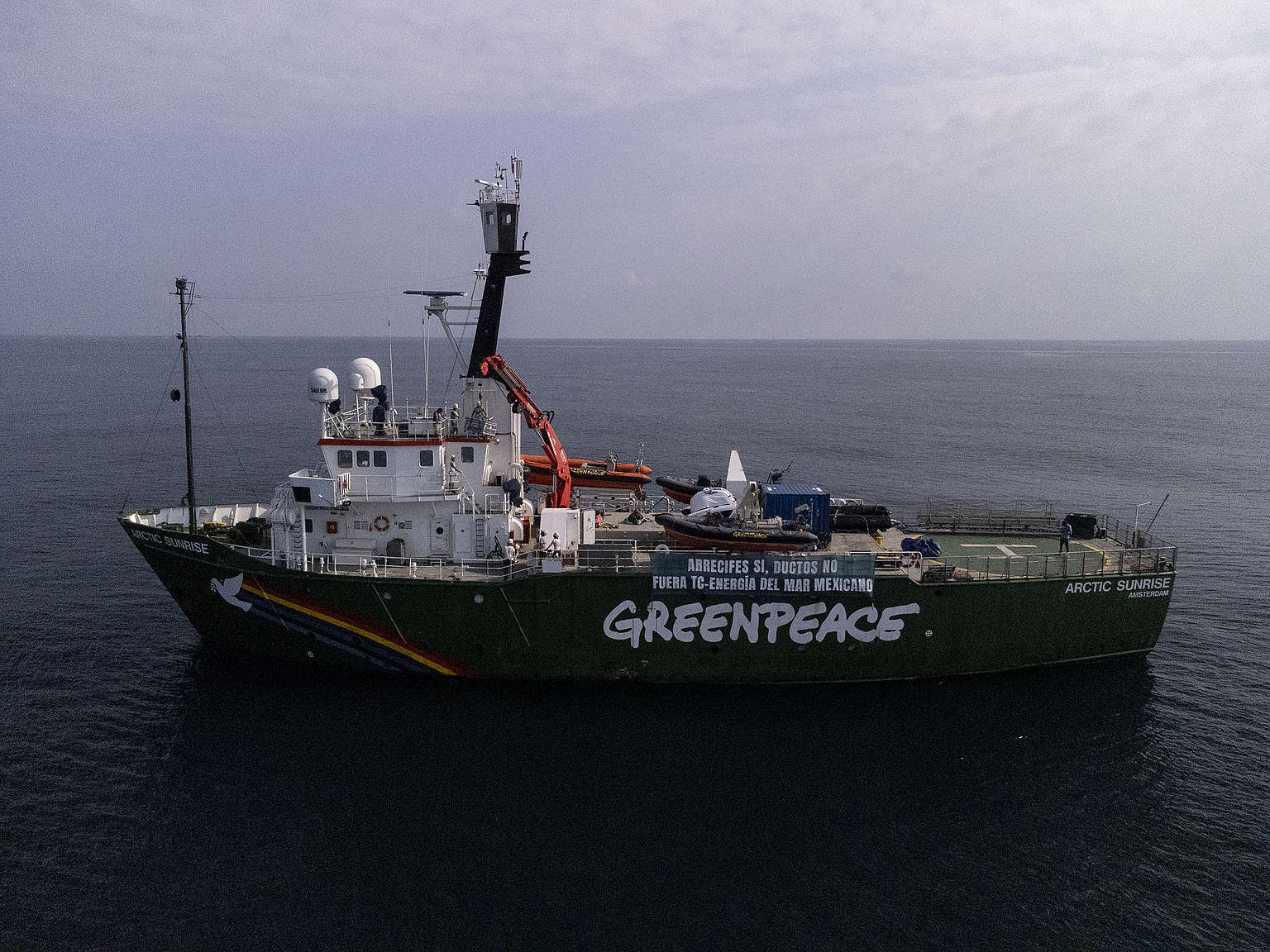 Fotografía panorámica del Arctic Sunrise en Veracruz con una manta que dice "Arrecifes sí, ductos no. Fuera TC Energía del mar mexicano".