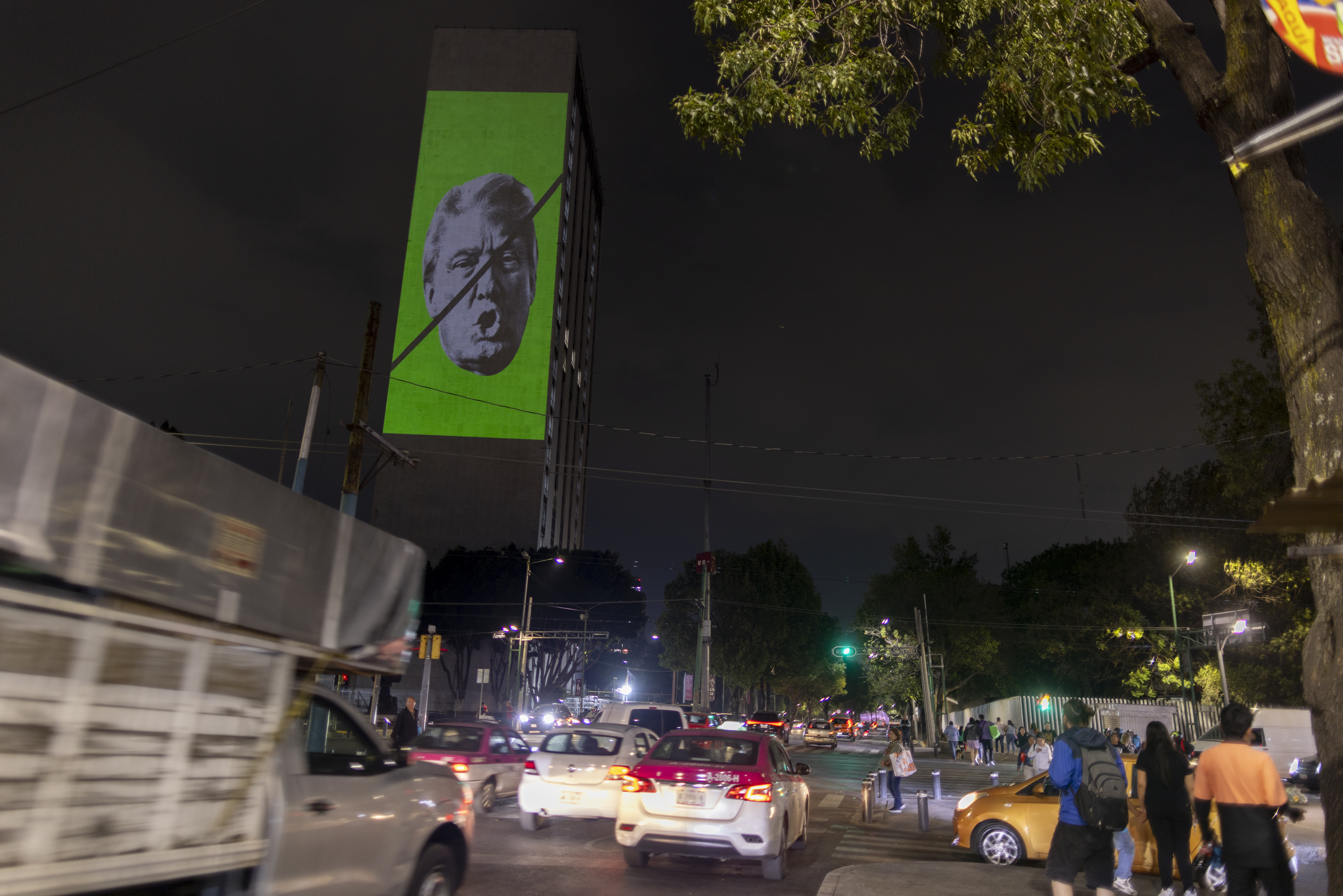 Proyección del rostro de Trump tachado en la plaza de las tres culturas.