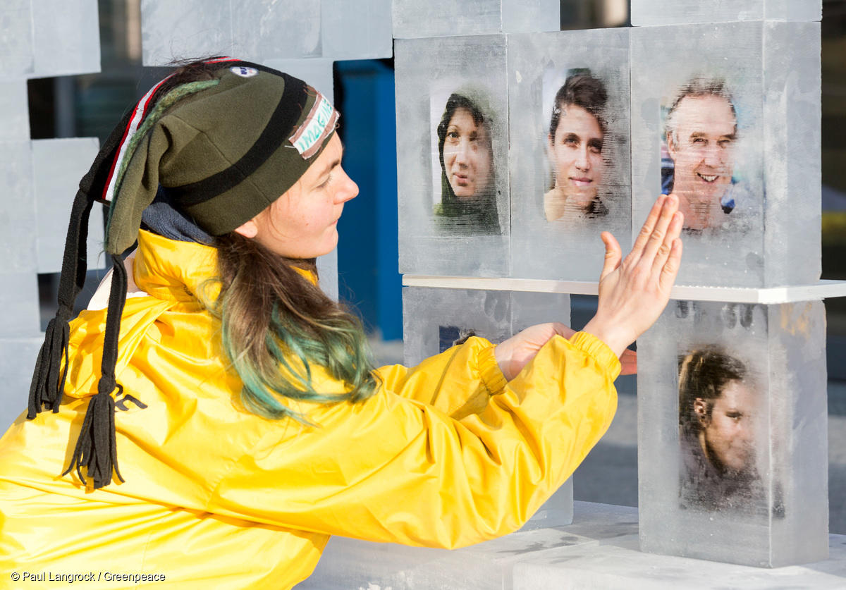 Mujer en protesta con retratos de los 30 del Ártico, congelados en cubitos de hielo, frente a la sede de Gazprom en Berlín. 