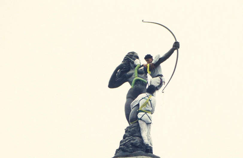 Activista de Greenpeace México prestando primeros auxilios a la Estatua de Diana, el símbolo de la ciudad, con una máscara de gas.