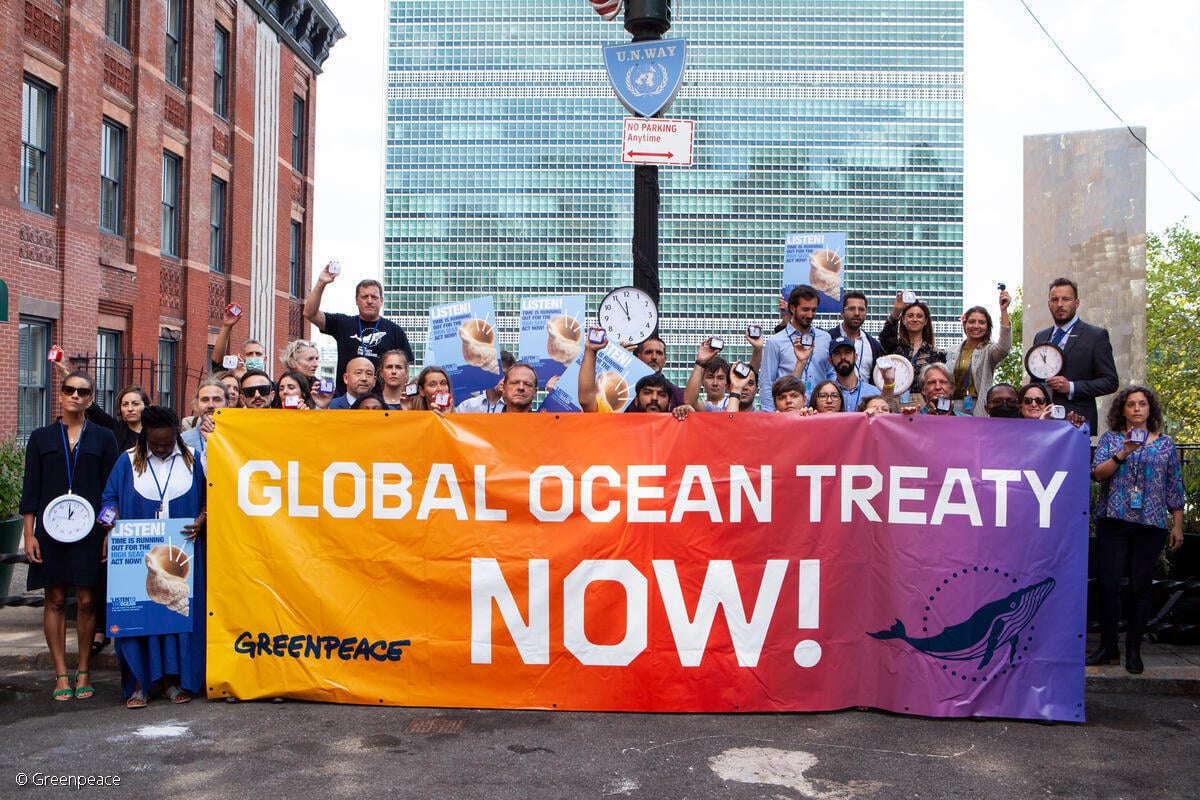 Fotografía de activistas de Greenpeace, junto con la Alianza de Alta Mar, sosteniendo una manta que dice "Tratado Global de Océanos ahora".