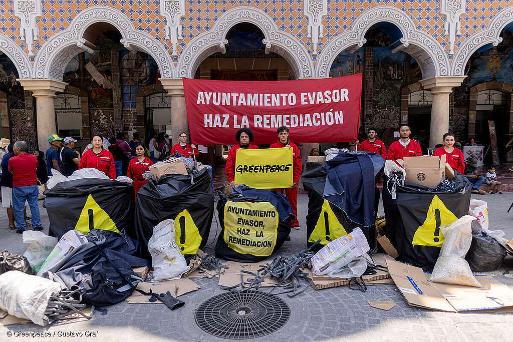 Un grupo de activistas de Greenpeace México y habitantes de Santa María Coapan junto a bolsas de basura y pancartas que dicen "Ayuntamiento evasor, haz la remediación". Un grupo de activistas de Greenpeace México y habitantes de Santa María Coapan junto a bolsas de basura y pancartas que dicen "Ayuntamiento evasor, haz la remediación".
