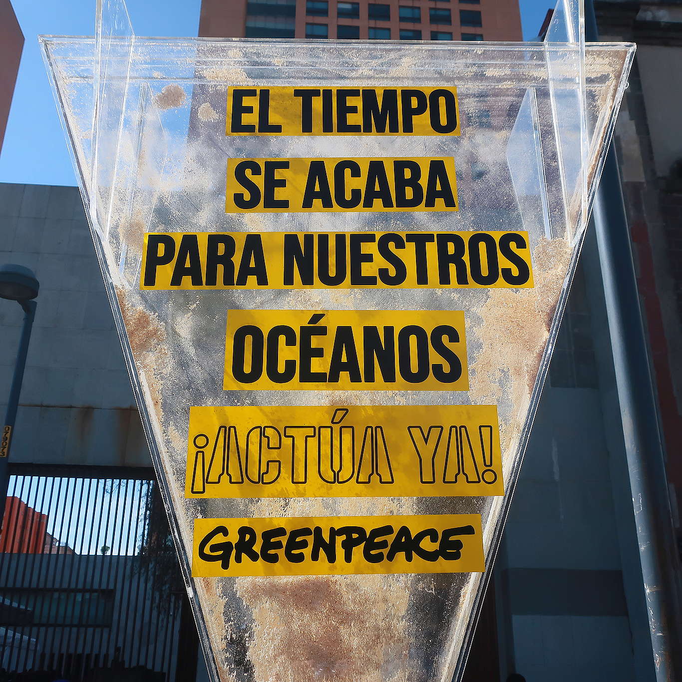 Fotografía de un reloj de arena gigante en el que se lee "El tiempo se acaba para nuestros océanos, actúa ya".