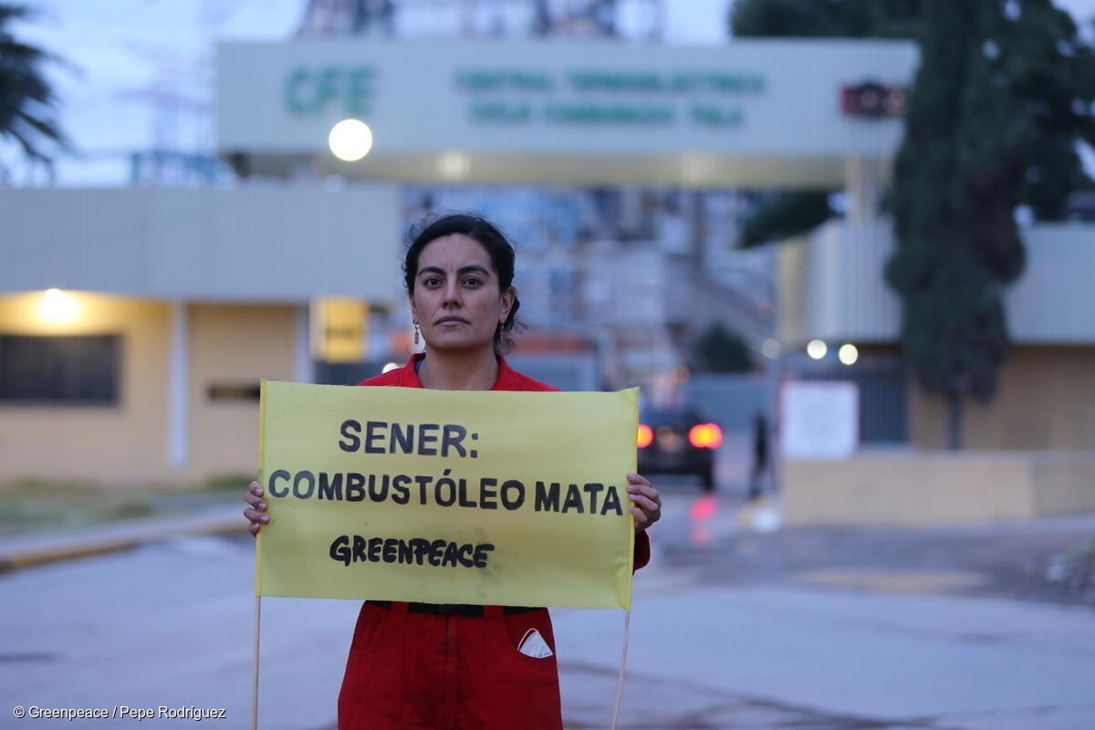 Un activista de Greenpeace México sostiene una pancarta de protesta en la planta termoeléctrica de Tula, Hidalgo en la que se lee "SENER: El combustóleo mata".