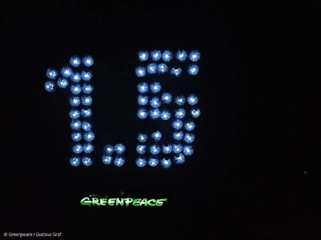 Activistas de Greenpeace México iluminan el mensaje de "1.5" con sombrillas en el marco de la COP27.