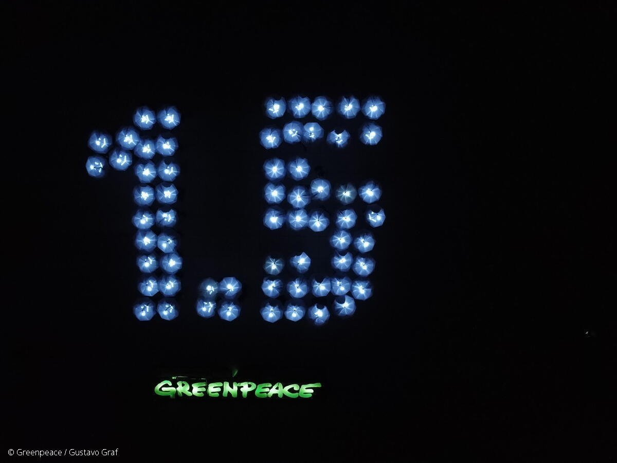 Activistas de Greenpeace México iluminan el mensaje de "1.5" con sombrillas en el marco de la COP27.