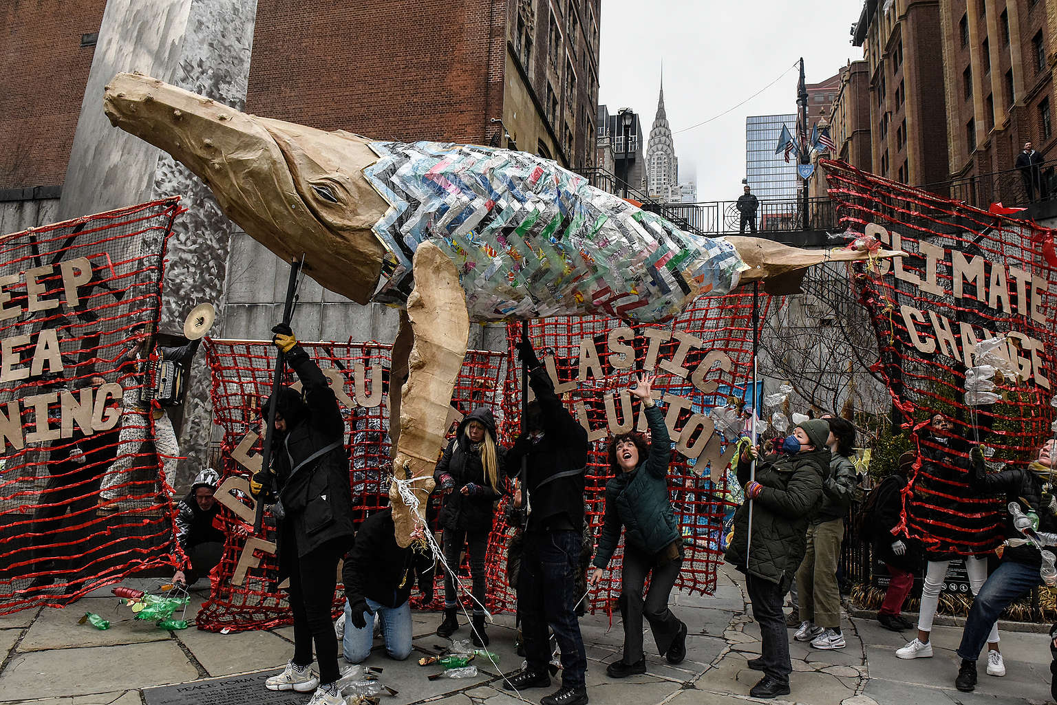 Activistas de Greenpeace afuera de las Naciones Unidas en Nueva York, entre instalación artística hecha de plásticos que evidencia la contaminación plástica de los oceános.